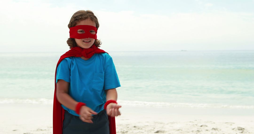 Happy Child Dressed as Superhero Playing at Beach - Free Images, Stock Photos and Pictures on Pikwizard.com