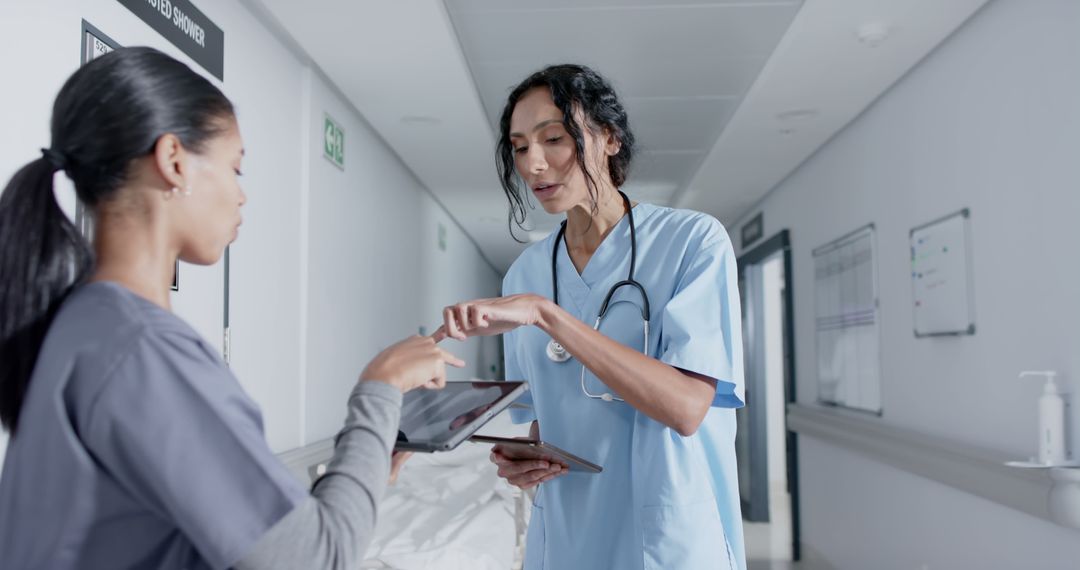 Two Healthcare Professionals Discussing Patient Details in Hospital Corridor - Free Images, Stock Photos and Pictures on Pikwizard.com