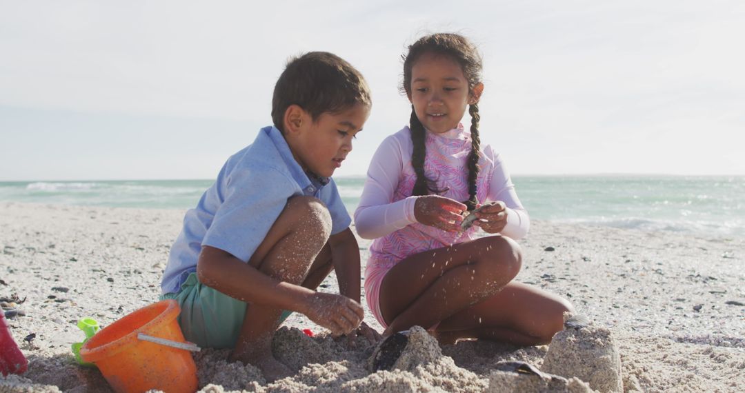 Siblings Enjoying Beach Playtime with Sand Creations