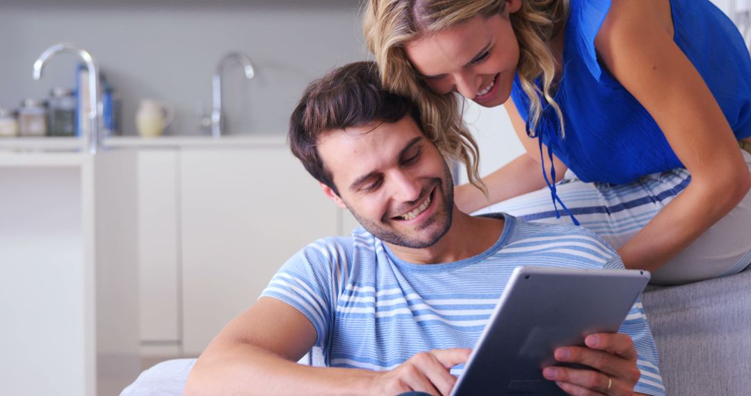 Happy Couple Checking Tablet in Modern Kitchen - Free Images, Stock Photos and Pictures on Pikwizard.com