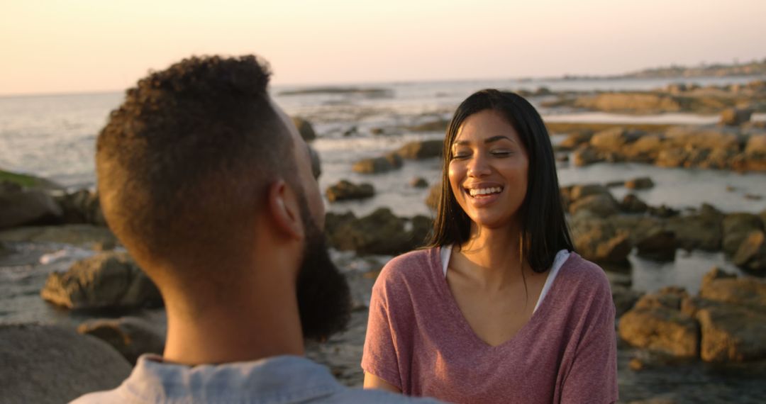 Happy Couple Smiling on Rocky Beach During Sunset - Free Images, Stock Photos and Pictures on Pikwizard.com