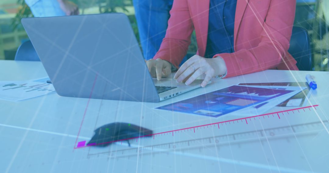 Businesswoman Analyzing Data on Laptop with Overlayed Graphs