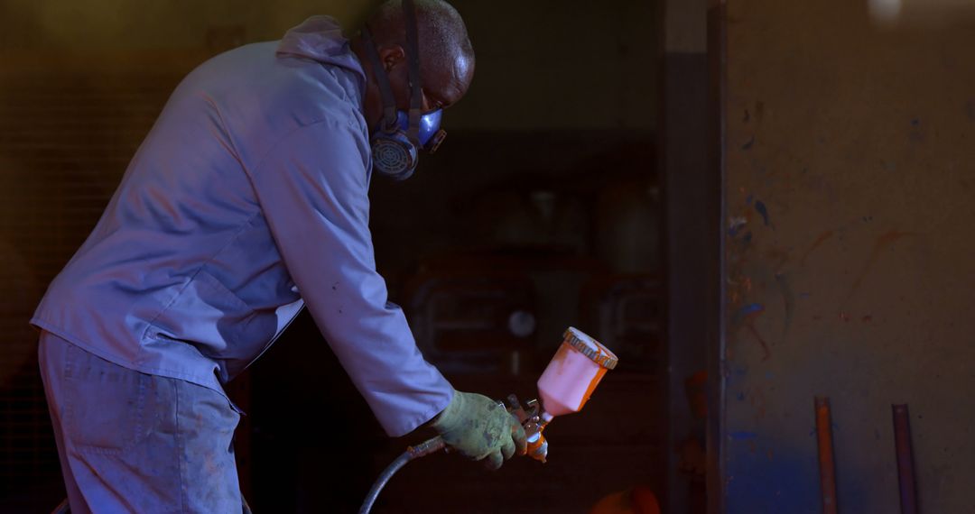 Worker Begins Spray Painting Metal Surface in Workshop - Free Images, Stock Photos and Pictures on Pikwizard.com