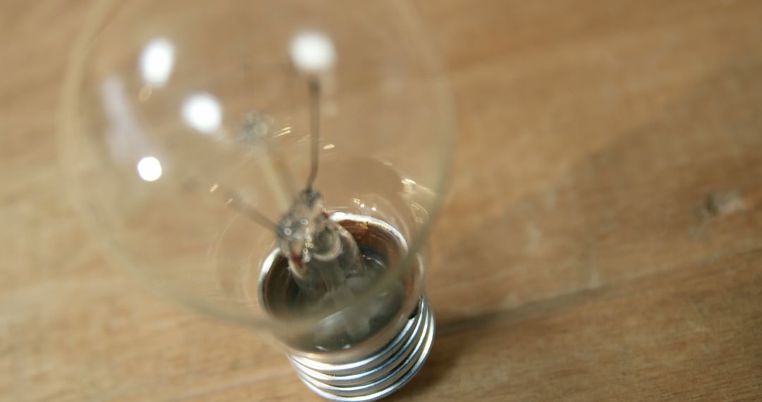 Classic Clear Light Bulb on Wooden Surface - Free Images, Stock Photos and Pictures on Pikwizard.com