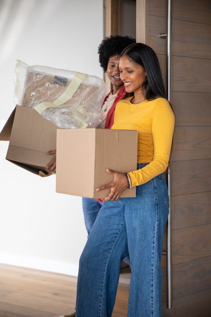 Diverse Couple Happily Moving into New Home with Boxes