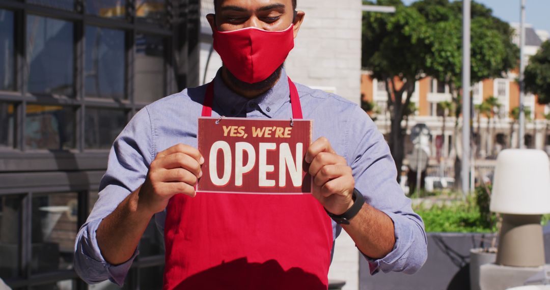 Store Employee Holding Open Sign Wearing Mask and Apron - Free Images, Stock Photos and Pictures on Pikwizard.com