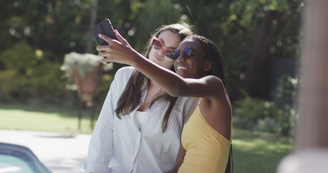 Two Women Taking Selfie in Garden on Sunny Day - Free Images, Stock Photos and Pictures on Pikwizard.com