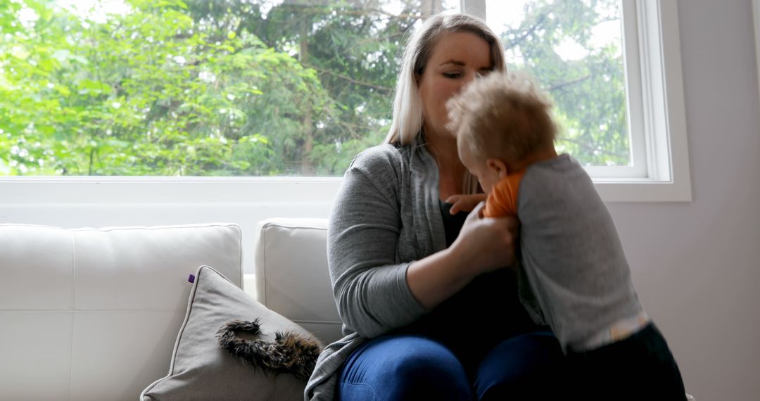 Mother Holding Child in Bright Living Room - Free Images, Stock Photos and Pictures on Pikwizard.com