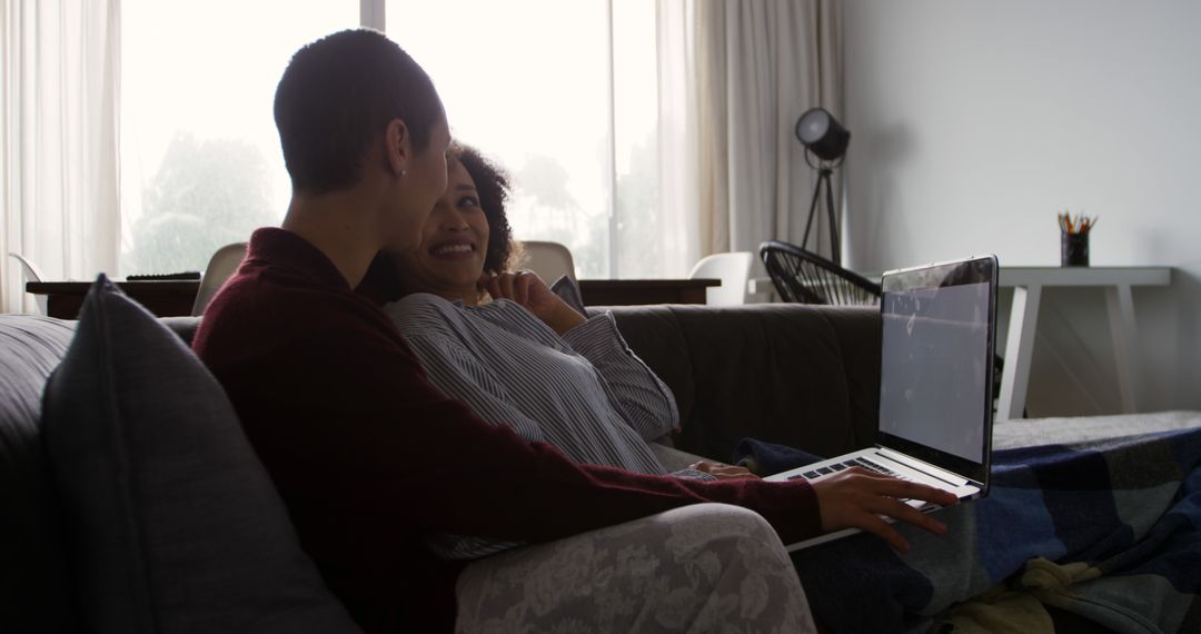 Lesbian Couple Relaxing on Couch with Laptop at Home