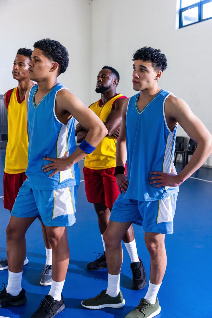 Focused Basketball Players Awaiting Directions in Gym