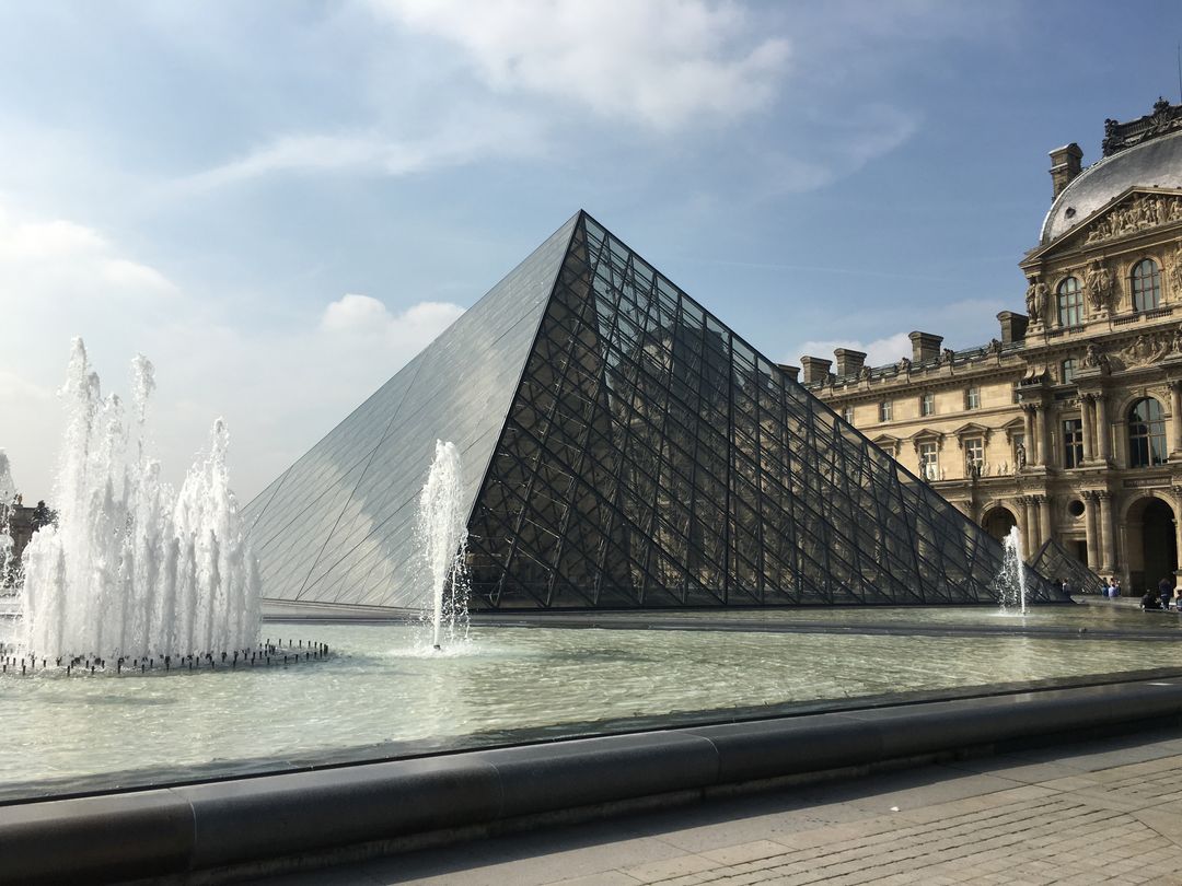 Louvre Museum Pyramid with Fountains on Sunny Day - Free Images, Stock Photos and Pictures on Pikwizard.com