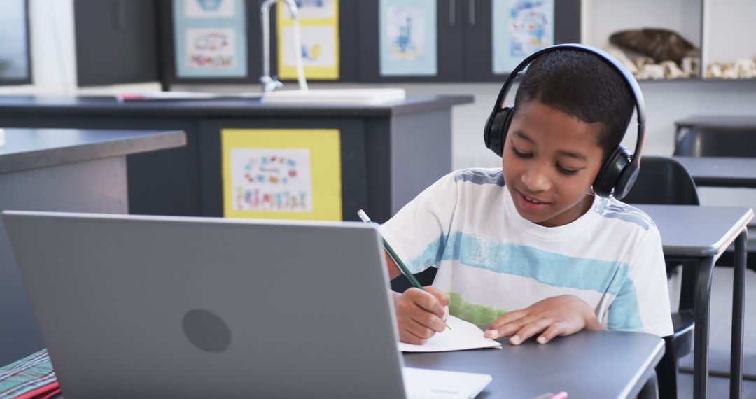 Young Student with Headphones Focused on Online Learning in Classroom