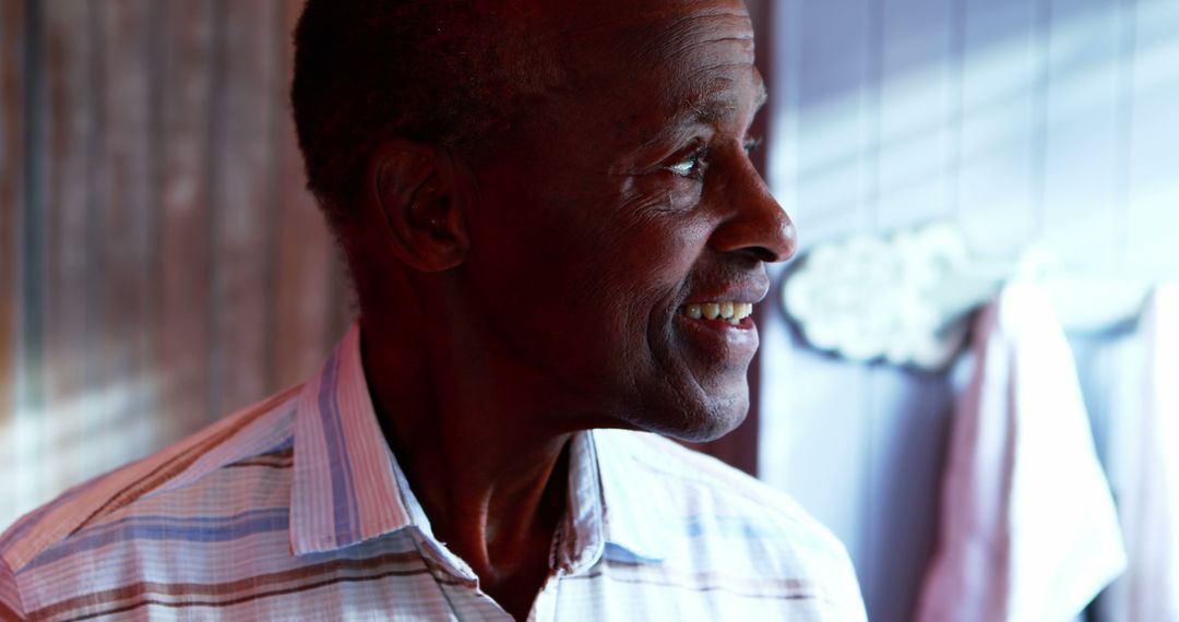 Joyful Man Looking Out Window in Cozy Home Environment