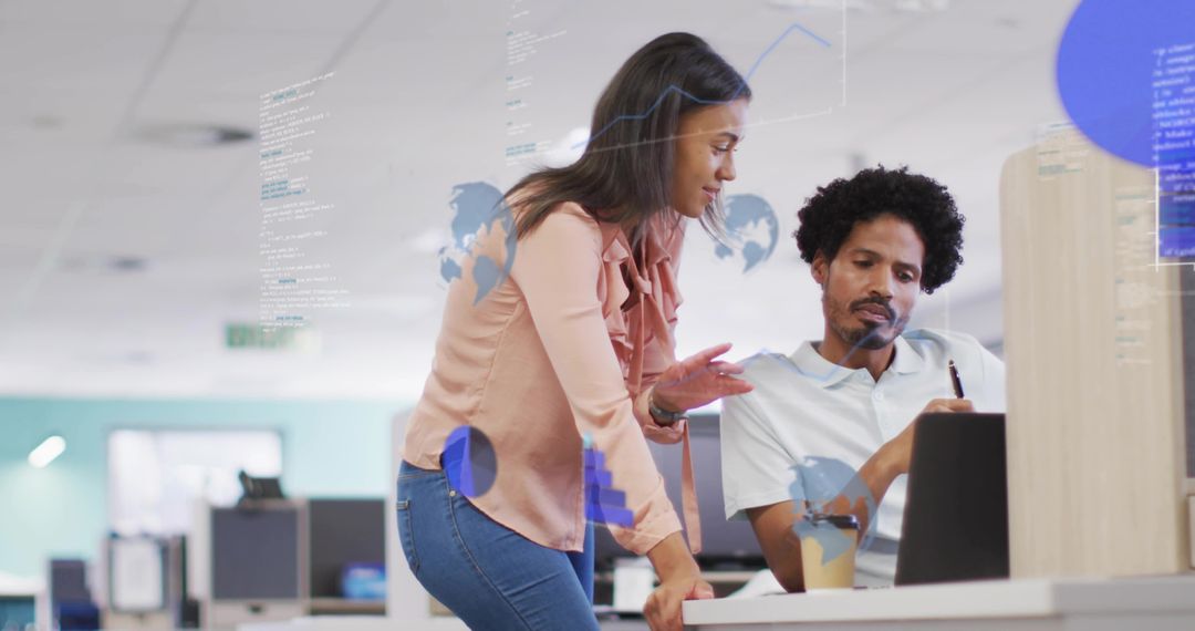 Colleagues collaborating over laptop with augmented data overlays in open-plan office