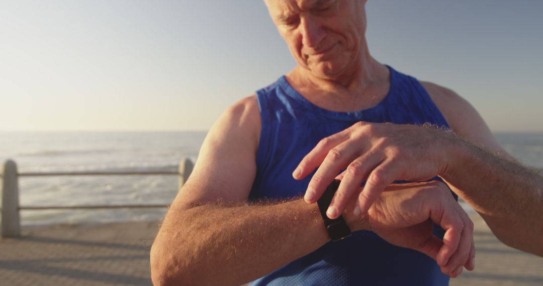 Active Senior Man Checking Fitness Tracker by Seaside During Morning Walk - Free Images, Stock Photos and Pictures on Pikwizard.com