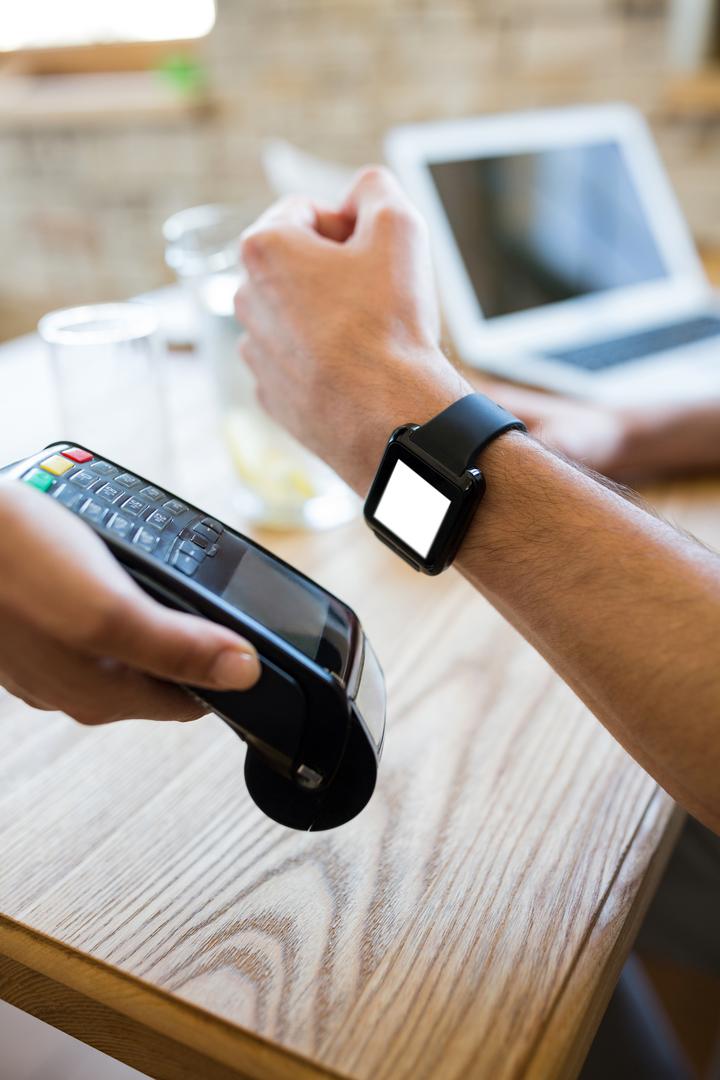Using Smartwatch for Contactless Payment at Cafe Table - Free Images, Stock Photos and Pictures on Pikwizard.com