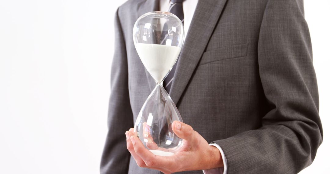 Businessman Holding Hourglass Symbolizing Time Management and Deadlines - Free Images, Stock Photos and Pictures on Pikwizard.com