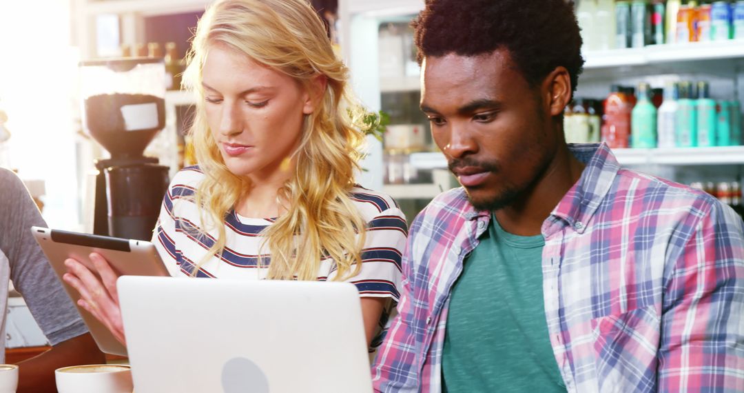 Diverse Entrepreneurs Collaborating in Sunny Cafe Environment