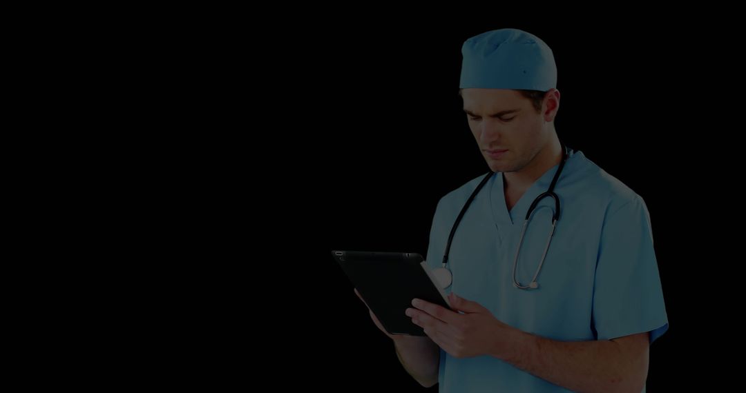 Surgeon in Scrubs Studying Tablet Technology Holding Stethoscope