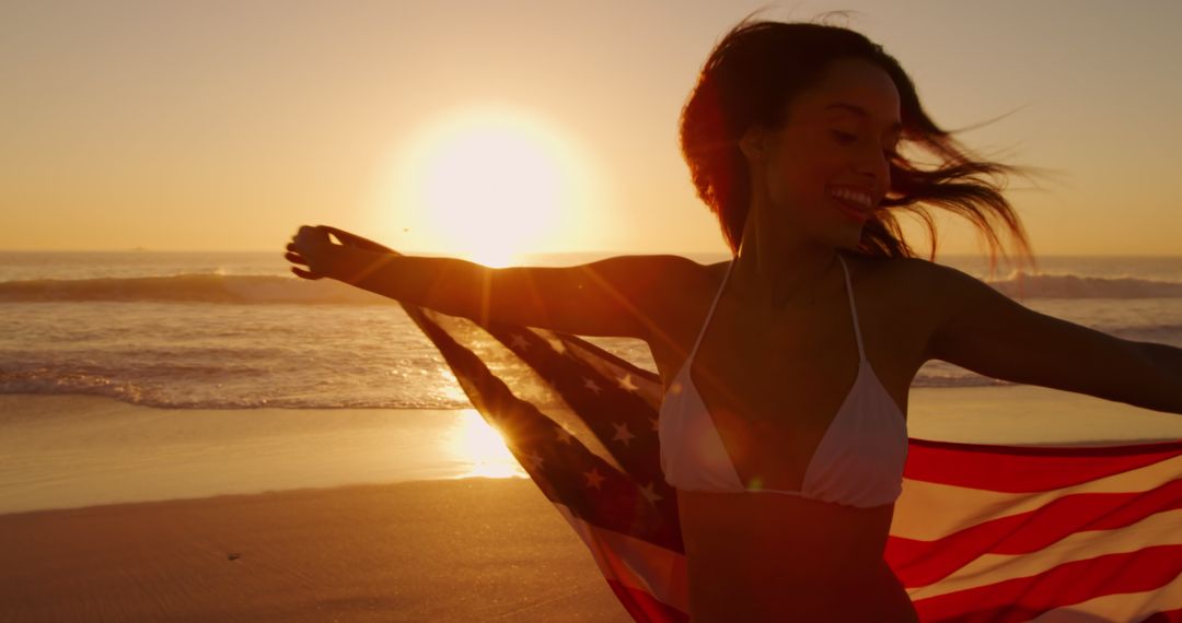 Joyful Woman in Bikini Holding American Flag on Sandy Beach at Sunset - Free Images, Stock Photos and Pictures on Pikwizard.com