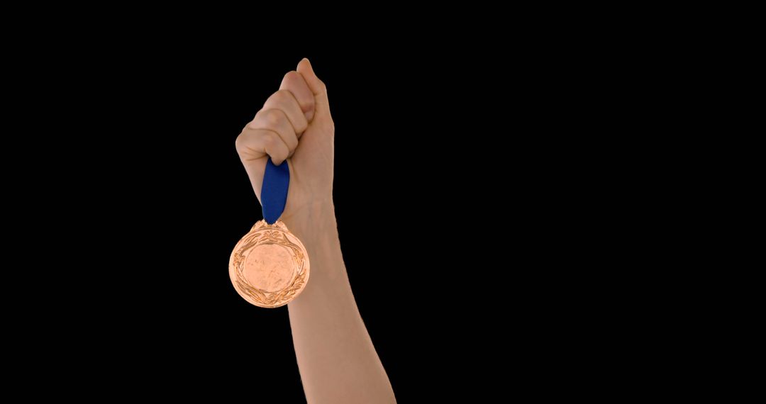 Hand Holding Bronze Medal Against Black Background - Free Images, Stock Photos and Pictures on Pikwizard.com