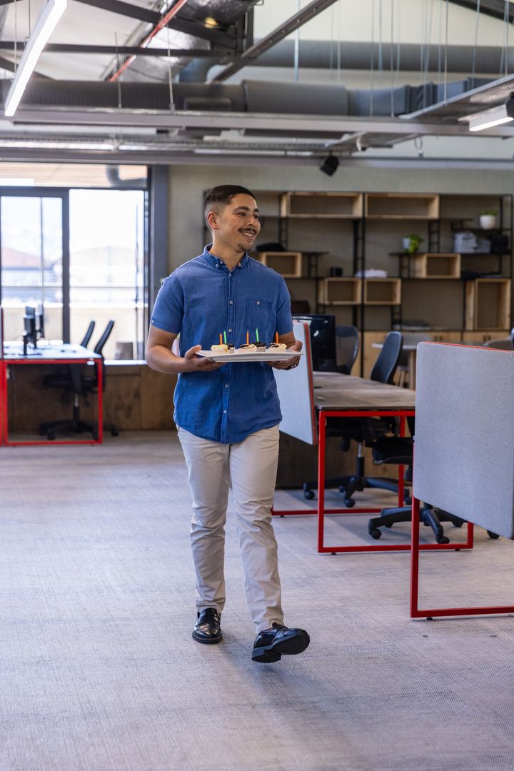 Office Worker Celebrating with Pastries in Modern Workspace