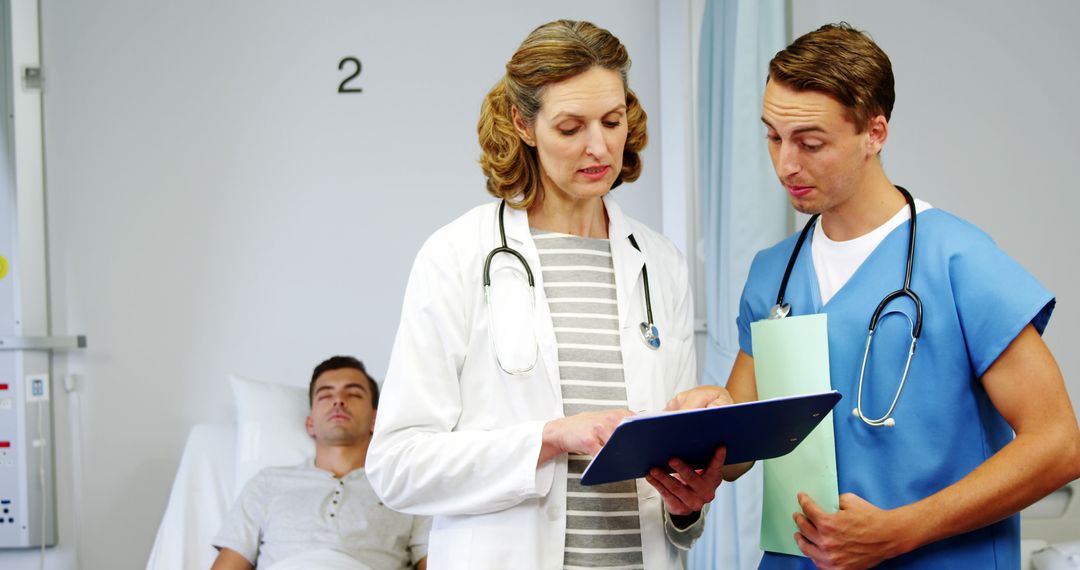 Doctors Reviewing Patient's Chart in the Hospital Ward - Free Images, Stock Photos and Pictures on Pikwizard.com