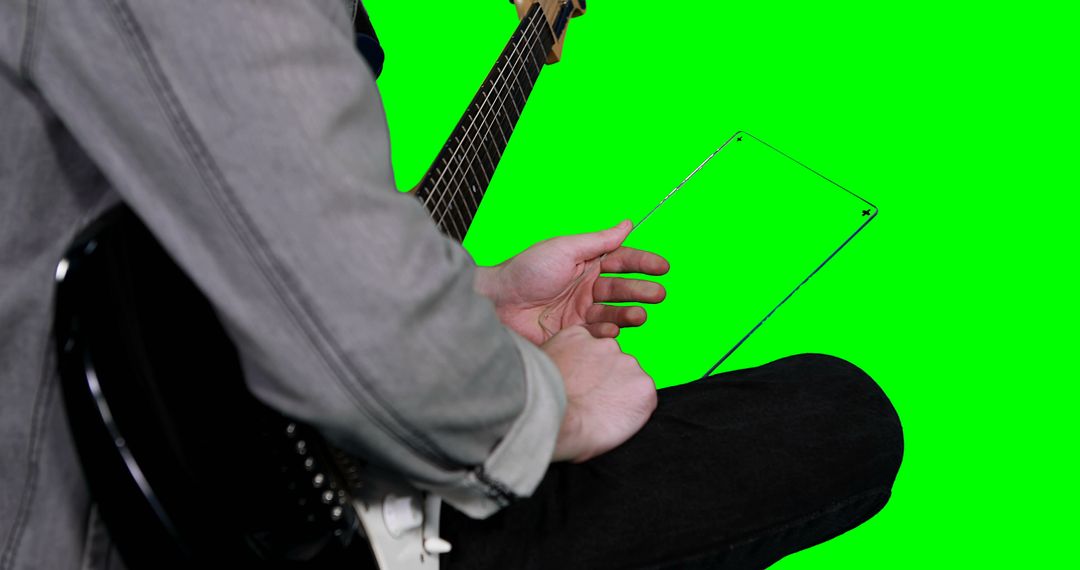 Musician Holding Transparent Tablet with Green Screen Background - Free Images, Stock Photos and Pictures on Pikwizard.com