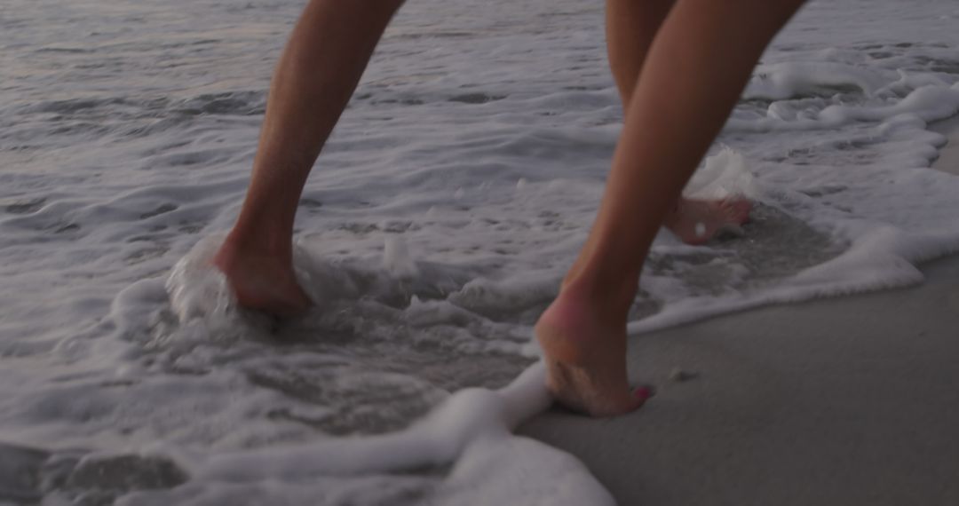 Close-Up of Bare Feet Walking on Beach Shoreline at Sunset - Free Images, Stock Photos and Pictures on Pikwizard.com