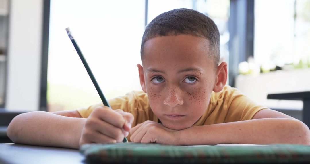 Young Student Concentrating on Homework in Classroom Setting