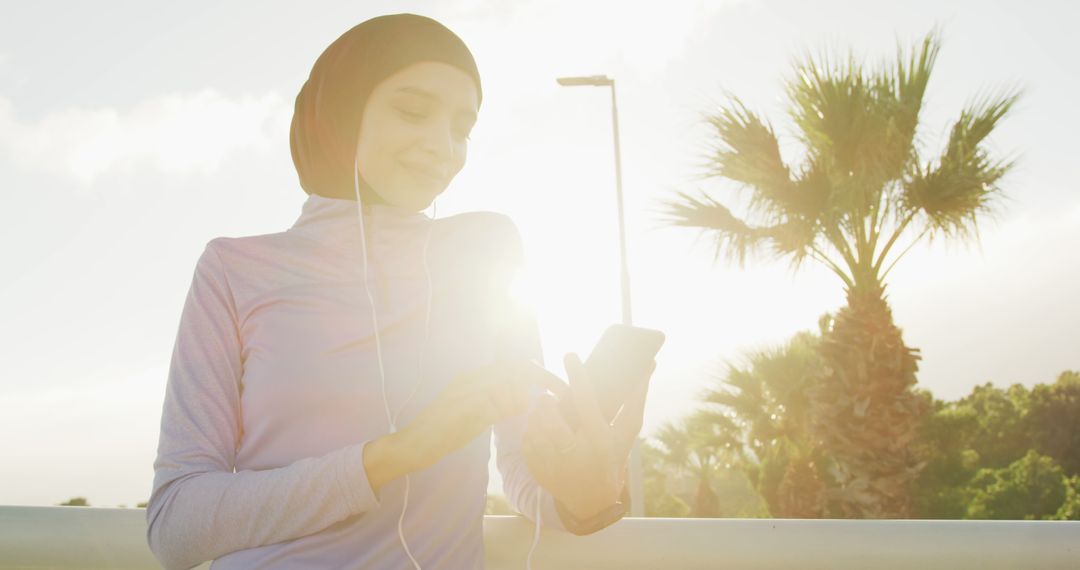 Muslim Woman Wearing Hijab and Using Smartphone Outdoors - Free Images, Stock Photos and Pictures on Pikwizard.com