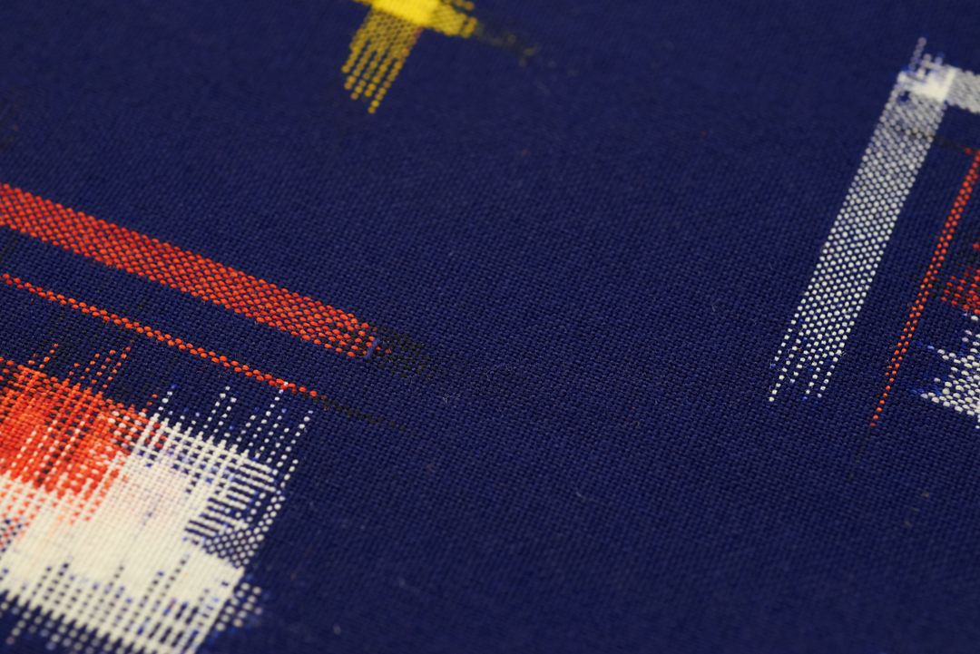 Featuring abstract pixel brush strokes in red white and yellow on navy woven fabric texture