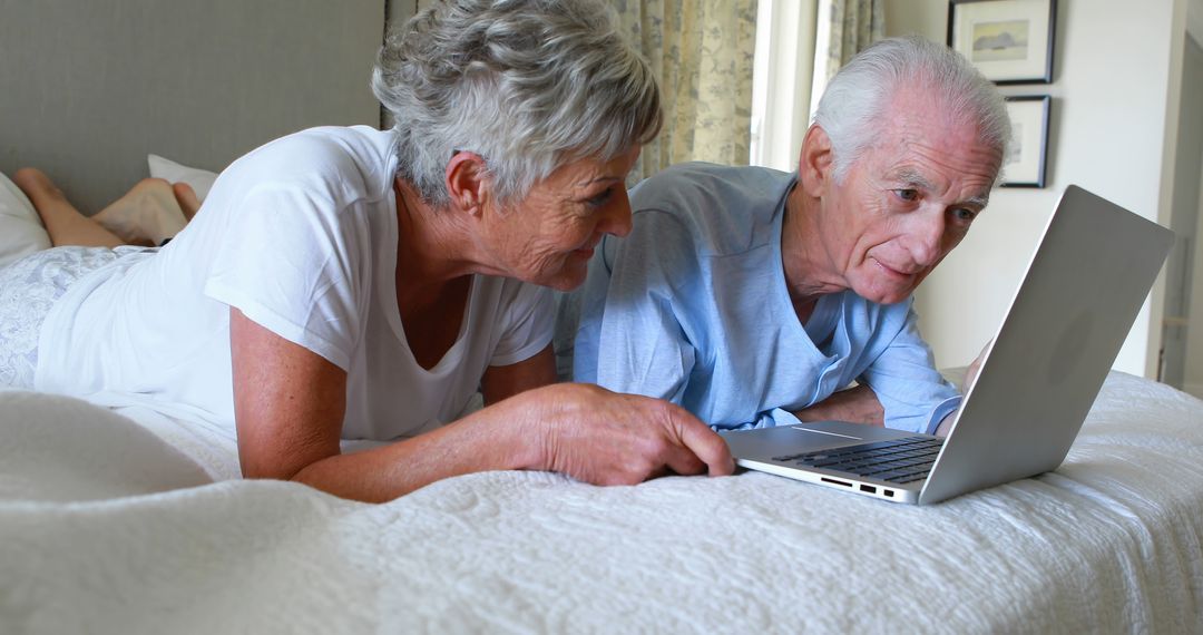 Senior Couple Using Laptop on Bed at Home - Free Images, Stock Photos and Pictures on Pikwizard.com