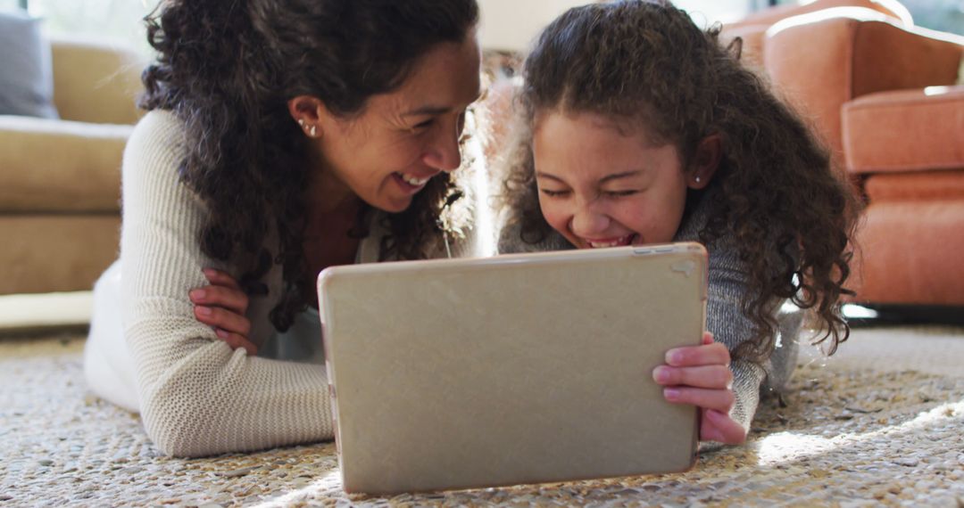 Smiling Mother and Daughter Watching Tablet Together at Home - Free Images, Stock Photos and Pictures on Pikwizard.com