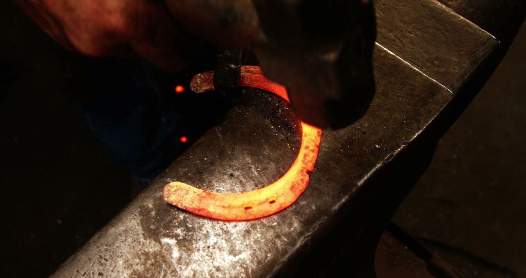 Blacksmith Shaping Red-Hot Horseshoe on Anvil