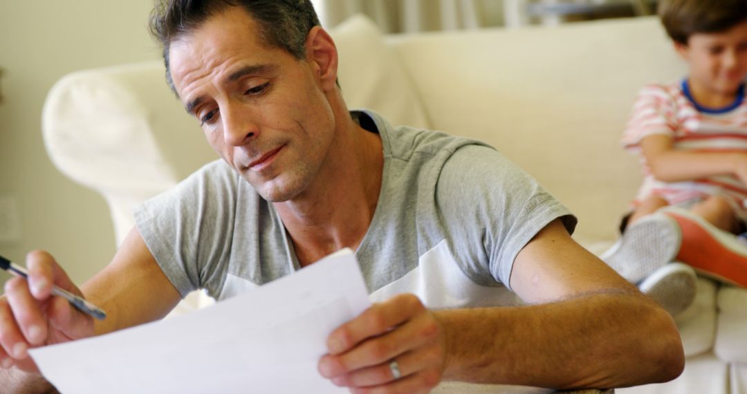 Middle-aged man reading documents at home - Free Images, Stock Photos and Pictures on Pikwizard.com