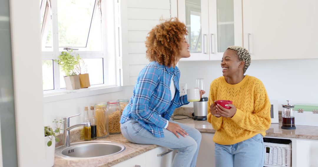 Cheerful Women Enjoying Morning Coffee in Modern Kitchen - Free Images, Stock Photos and Pictures on Pikwizard.com