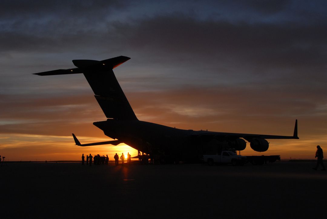 Sunset Silhouette of Air Force Cargo Plane Unloading at Vandenberg Air Force Base - Free Images, Stock Photos and Pictures on Pikwizard.com