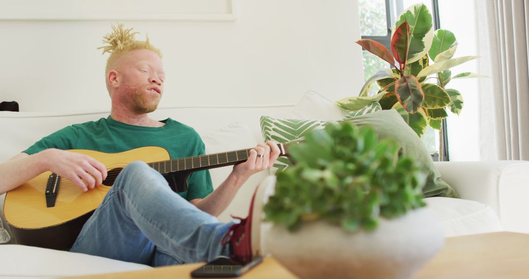 Man with Guitar Relaxing at Home in Bright Living Room - Free Images, Stock Photos and Pictures on Pikwizard.com