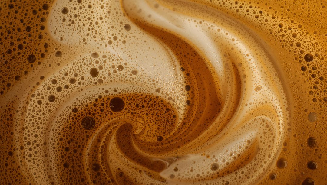 Swirling Espresso Crema and Milk Foam Macro Close-up Creating Creamy Brown Swirl