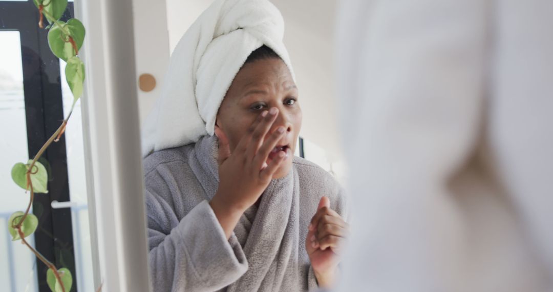 Woman Applying Skincare Cream In Bathroom Mirror - Free Images, Stock Photos and Pictures on Pikwizard.com