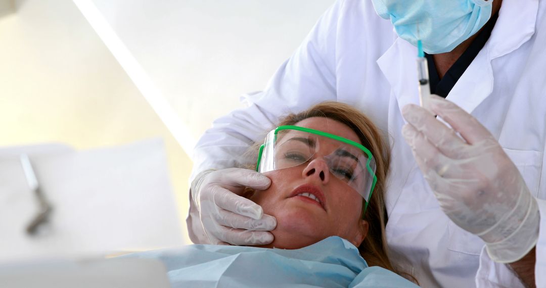 Dentist Administering Anesthetic Injection to Female Patient During Dental Procedure - Free Images, Stock Photos and Pictures on Pikwizard.com