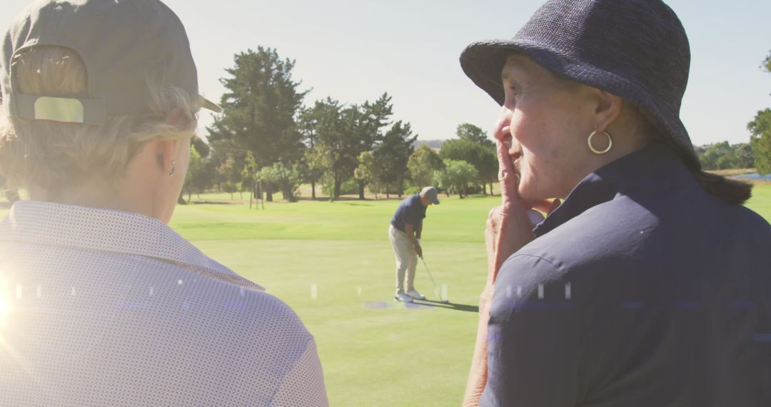 Senior Couple Watching Concurrent Golfer on Sunny Golf Course