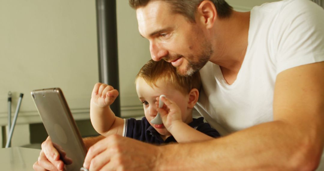 Father and Toddler Son Using Tablet Together at Home - Free Images, Stock Photos and Pictures on Pikwizard.com