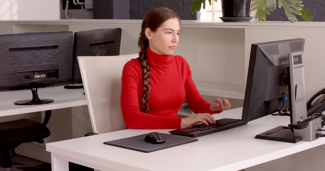 Focused Woman Typing on Keyboard at Modern Office Workspace