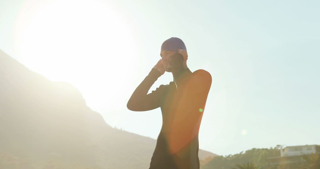 Silhouette of Swimmer Preparing Outdoors in Sunlight - Free Images, Stock Photos and Pictures on Pikwizard.com