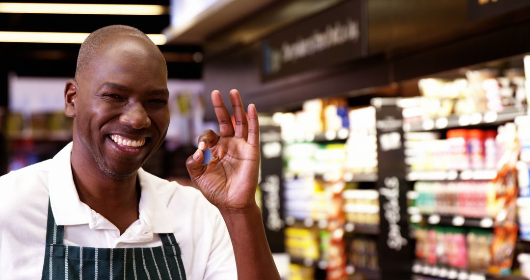 Smiling Supermarket Worker Giving OK Sign in Grocery Aisle - Free Images, Stock Photos and Pictures on Pikwizard.com