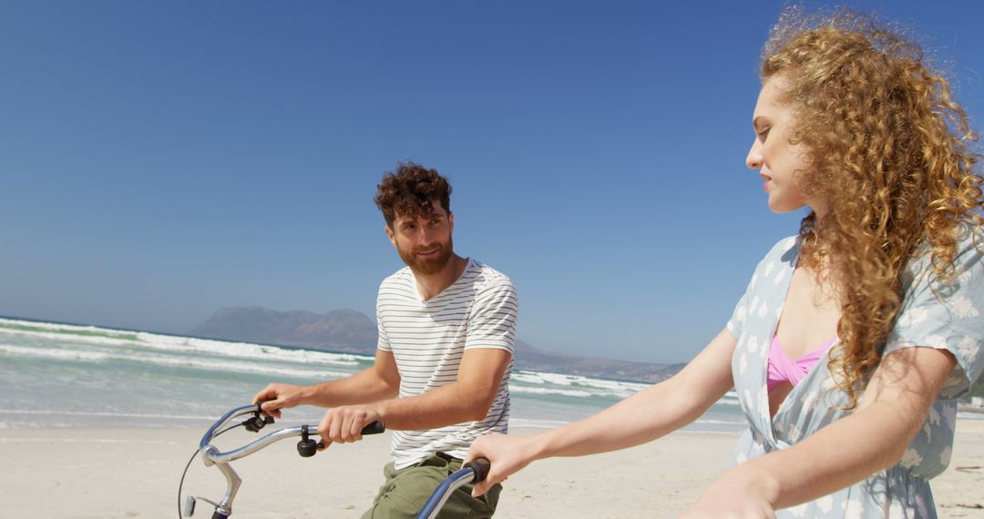 Young Couple Riding Bicycles on Beach Under Clear Sky - Free Images, Stock Photos and Pictures on Pikwizard.com