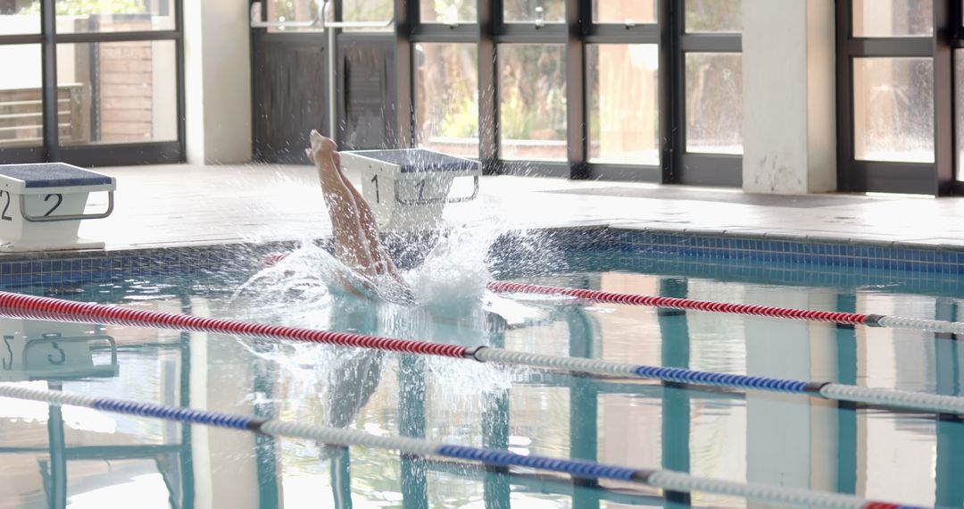 Swimmer Diving from Starting Block Creating Splash