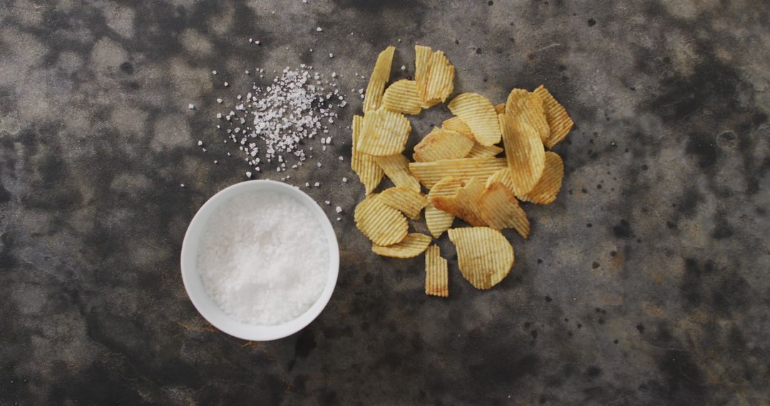 Salted Potato Chips and Bowl of Coarse Salt on Dark Background - Free Images, Stock Photos and Pictures on Pikwizard.com